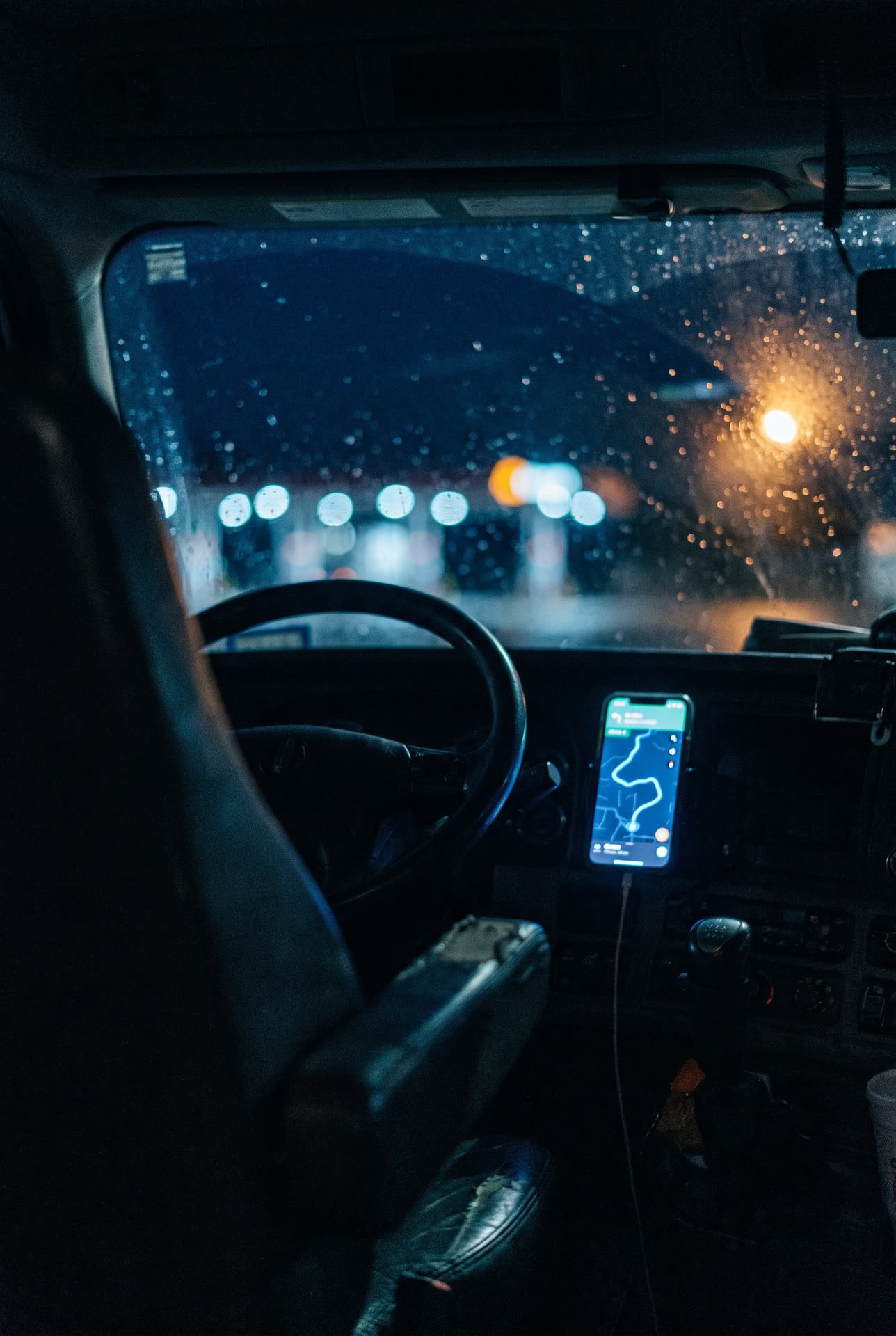 Phone mounted in a truck cab at night, glowing with a route